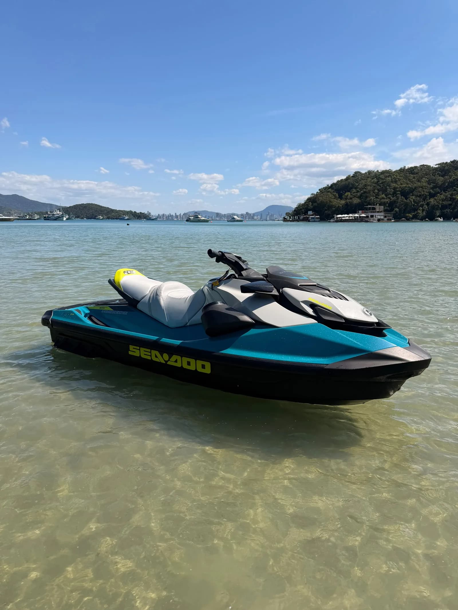 Jet ski em água rasa e cristalina sob céu azul em Porto Belo