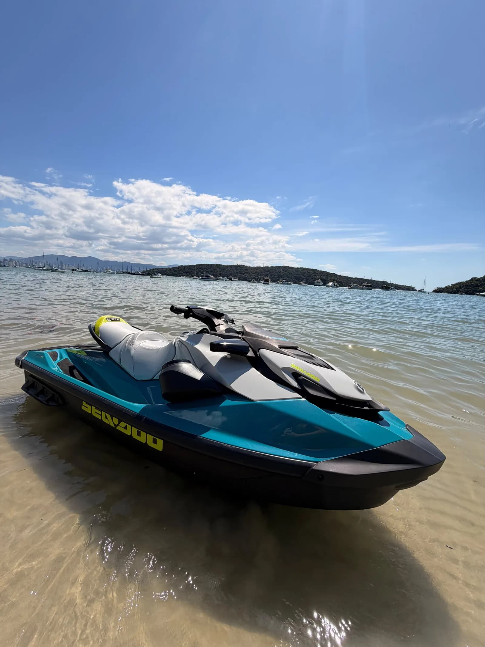 Jet ski navegando com a praia e a cidade de Porto Belo ao fundo
